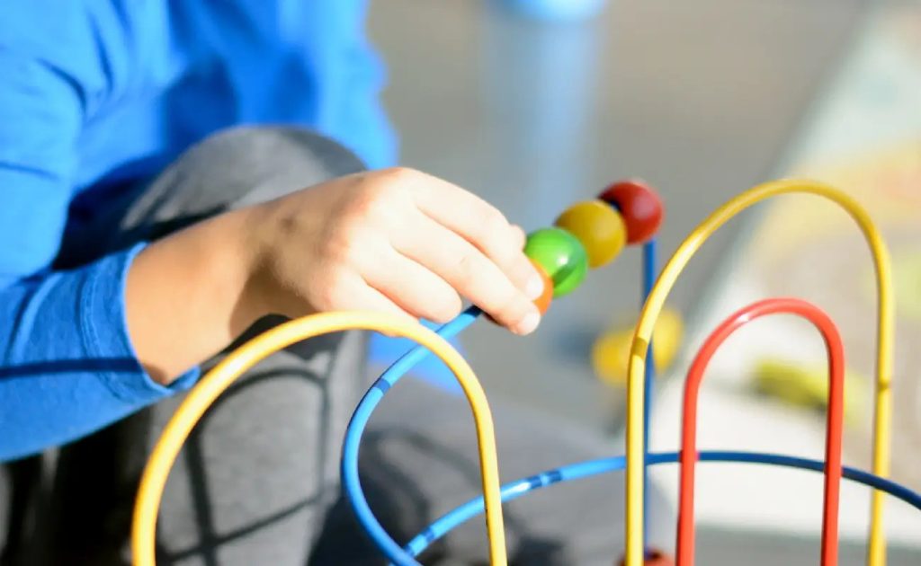 autistic-child-playing-with-colorful-abacus-for-sensory-integration-therapy